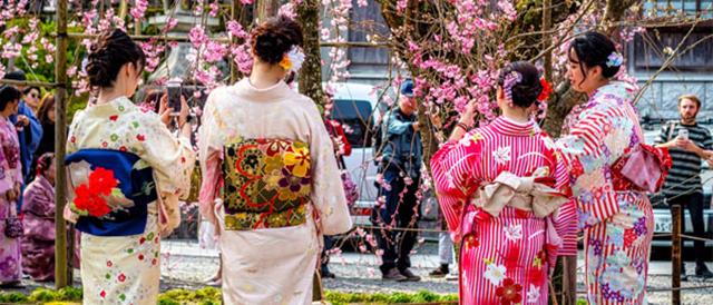 two women in kimonos st和ing next to each other.